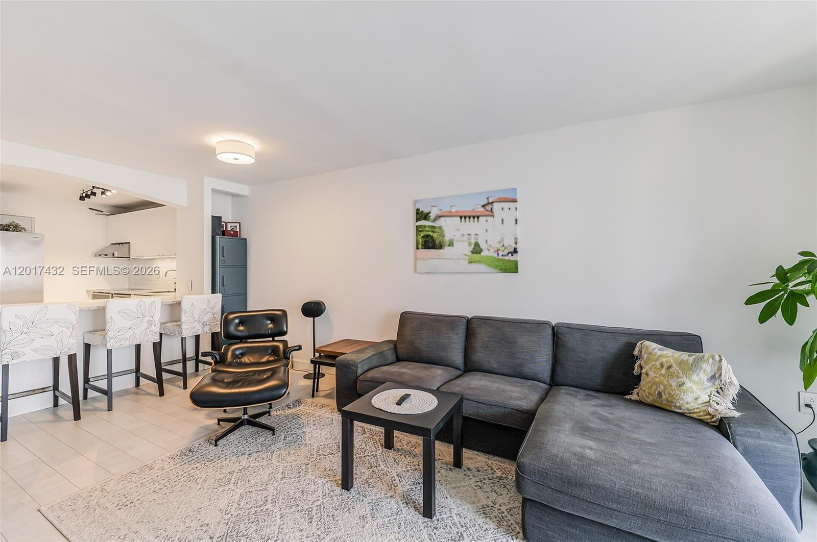 A living room features a gray sectional sofa, a black lounge chair, and a rug — 1331 Lincoln Rd # 704, Miami Beach FL 33139, MIAMI BEACH, FL