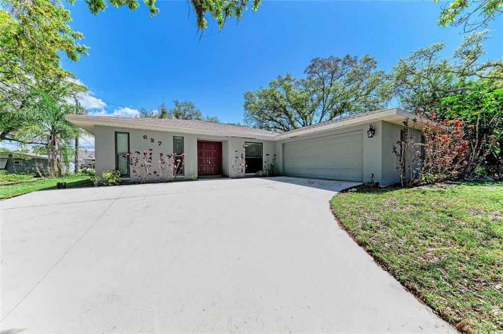 A single-story house with a gray exterior, a two-car garage, and a concrete driveway — 627 ALLIGATOR DRIVE, VENICE, FL