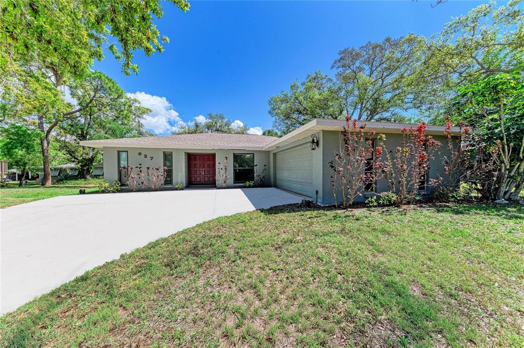 A single-story house with a gray exterior, a two-car garage, and a concrete driveway — 627 ALLIGATOR DRIVE, VENICE, FL