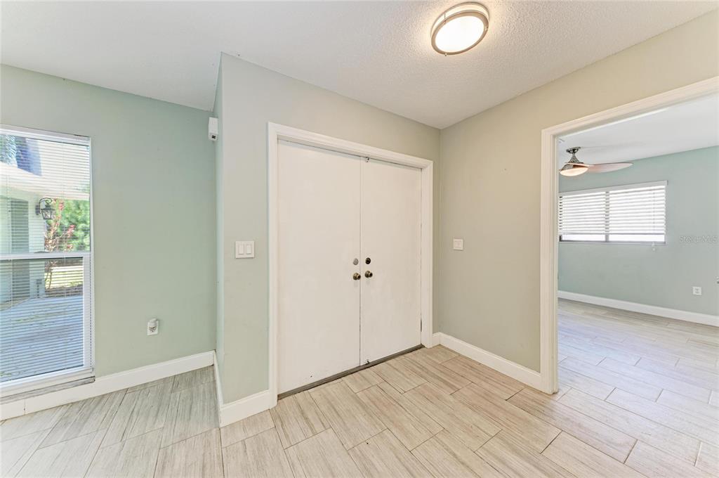 An interior view of a room with light green walls, tile flooring, and double doors — 627 ALLIGATOR DRIVE, VENICE, FL
