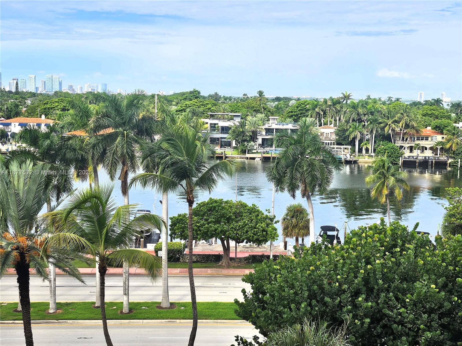 An elevated view of a waterway lined with palm trees, houses, and a road — 5161 Collins Ave # 707, Miami Beach FL 33140, MIAMI BEACH, FL