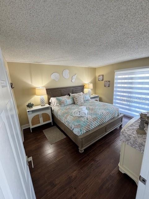 A bedroom features a queen bed, two nightstands, and a window with blinds on wood floors — 708 GULF BOULEVARD UNIT D, INDIAN ROCKS BEACH, FL