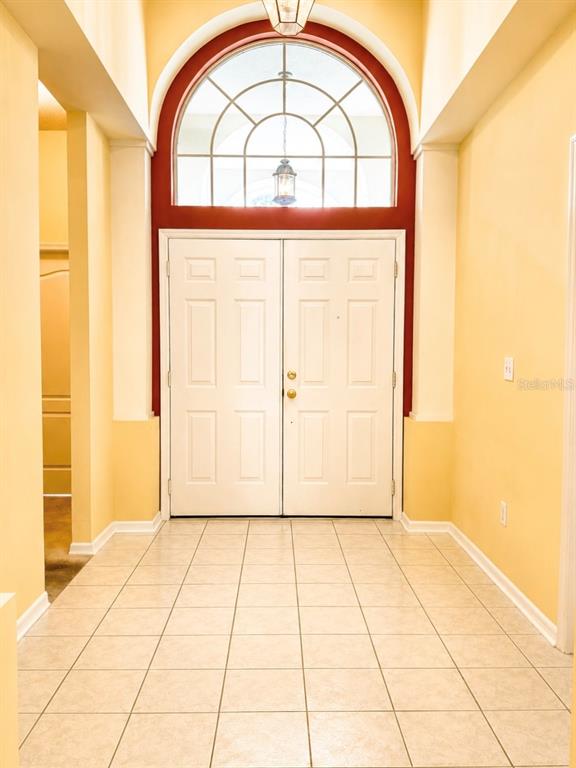 An entryway features white double doors, a large arched window, and light-colored tile flooring — 1995 EMERALD GREEN CIRCLE, OVIEDO, FL
