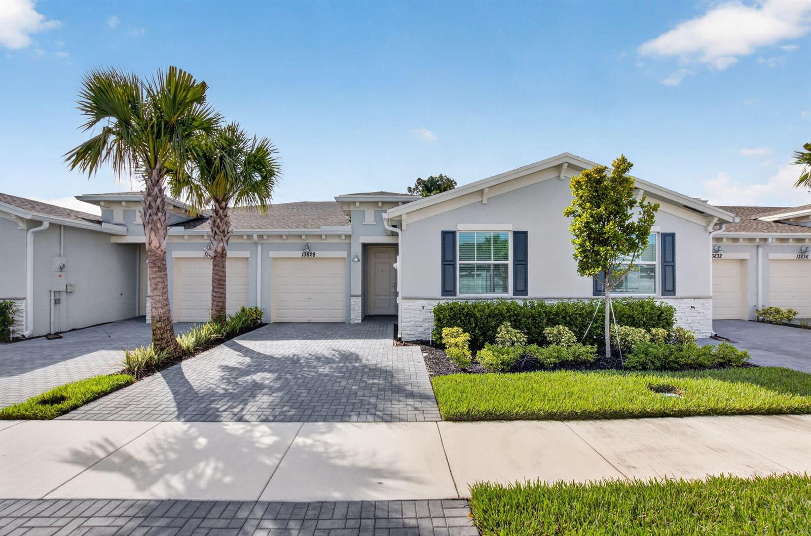 A single-story attached home features a paved driveway, two palm trees, and a front lawn — 13828 Hero Path, Delray Beach FL 33484, DELRAY BEACH, FL