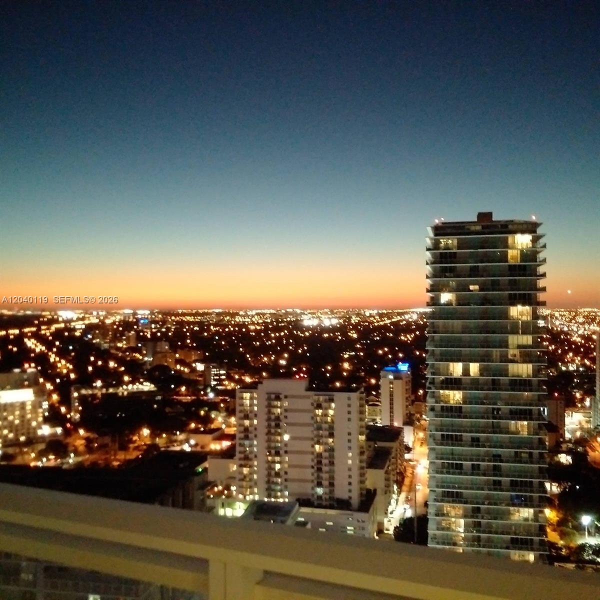 An elevated view of a city skyline at dusk with several high-rise residential buildings — 1080 Brickell Ave # 3203, Miami FL 33131, MIAMI, FL