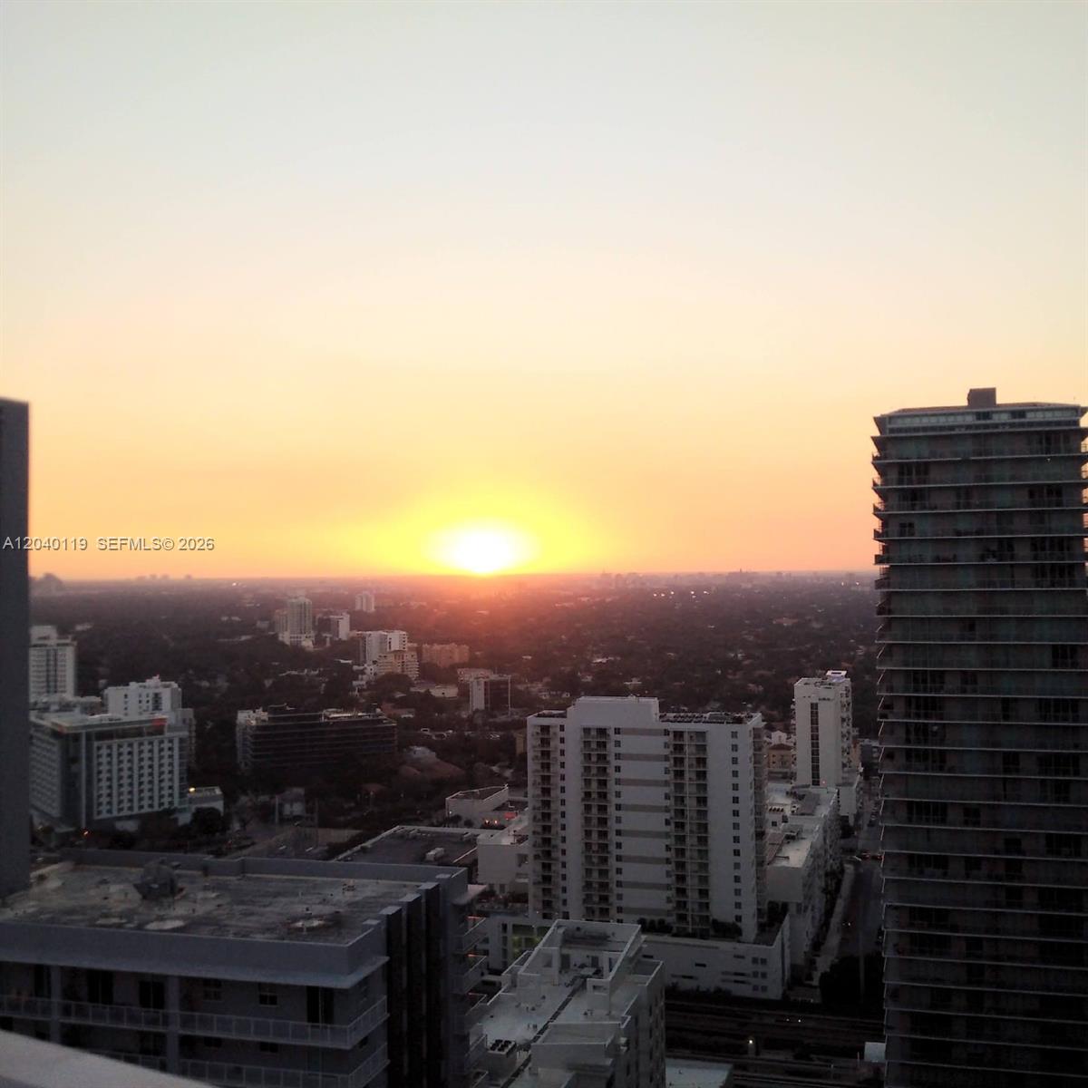 An elevated view of a city skyline at sunset with several high-rise buildings — 1080 Brickell Ave # 3203, Miami FL 33131, MIAMI, FL