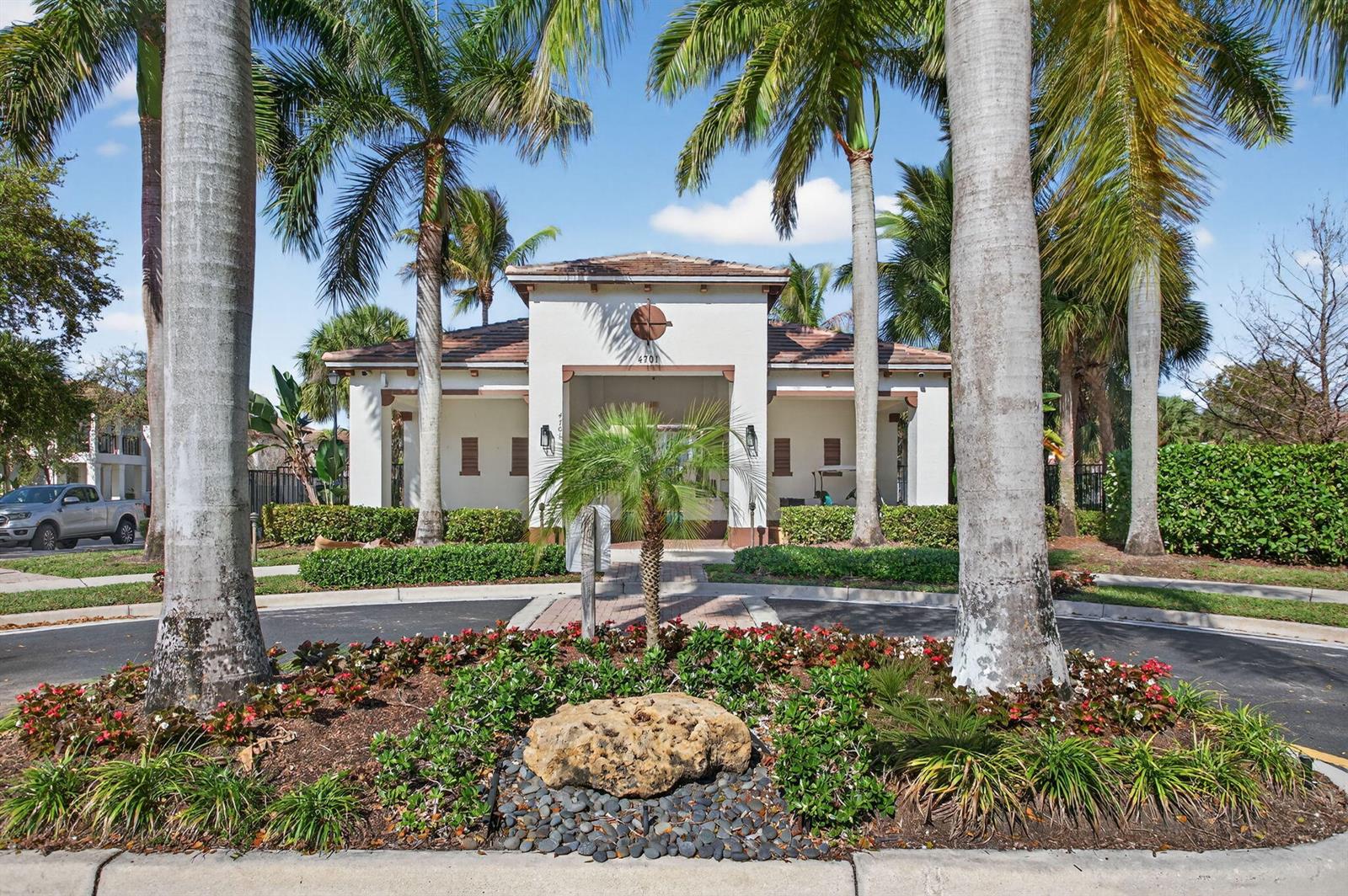 A low-rise building with a tiled roof stands behind a landscaped circular driveway — 4718 Monarch Way, Coconut Creek FL 33073, COCONUT CREEK, FL