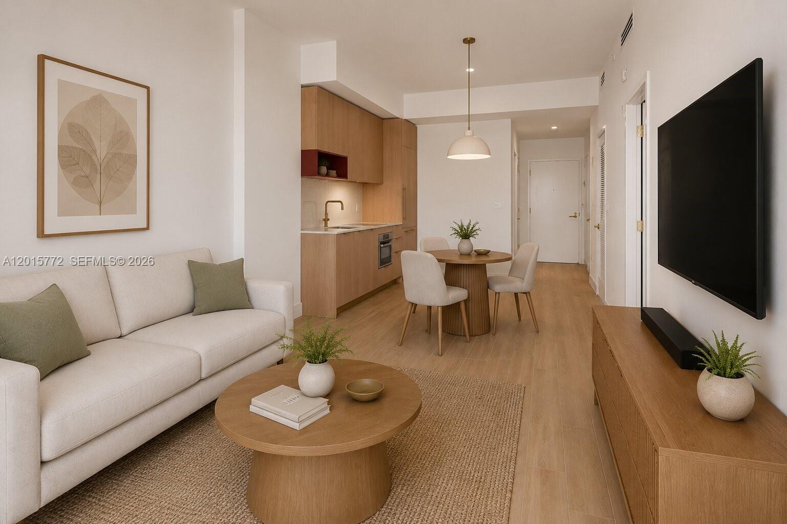 This living room and kitchen area features light wood flooring, neutral furniture, and modern cabinetry — 90 NE 32nd St # 211, Miami FL 33127, MIAMI, FL