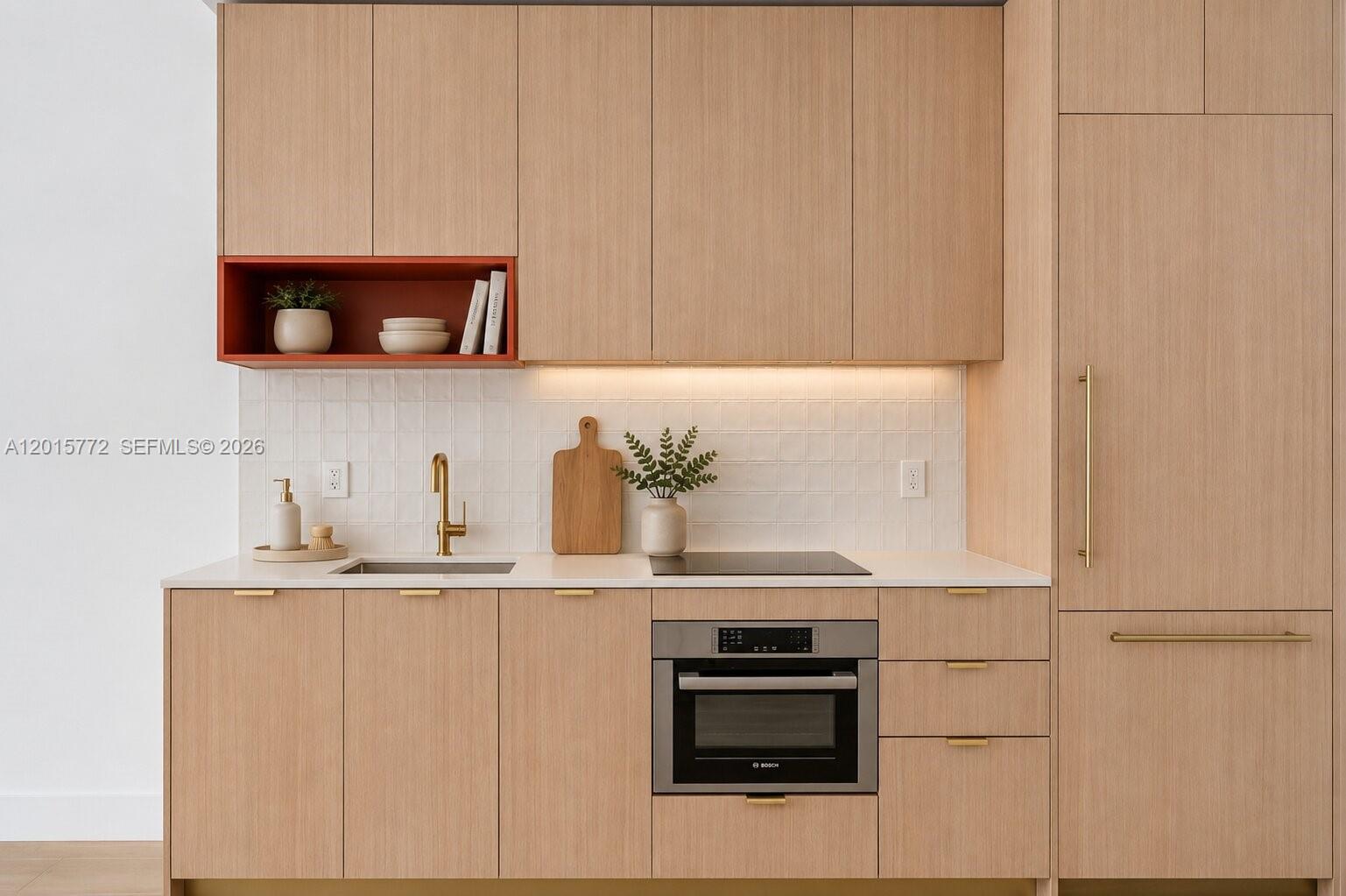A modern kitchen features light wood cabinetry, a white tiled backsplash, and a built-in oven — 90 NE 32nd St # 211, Miami FL 33127, MIAMI, FL