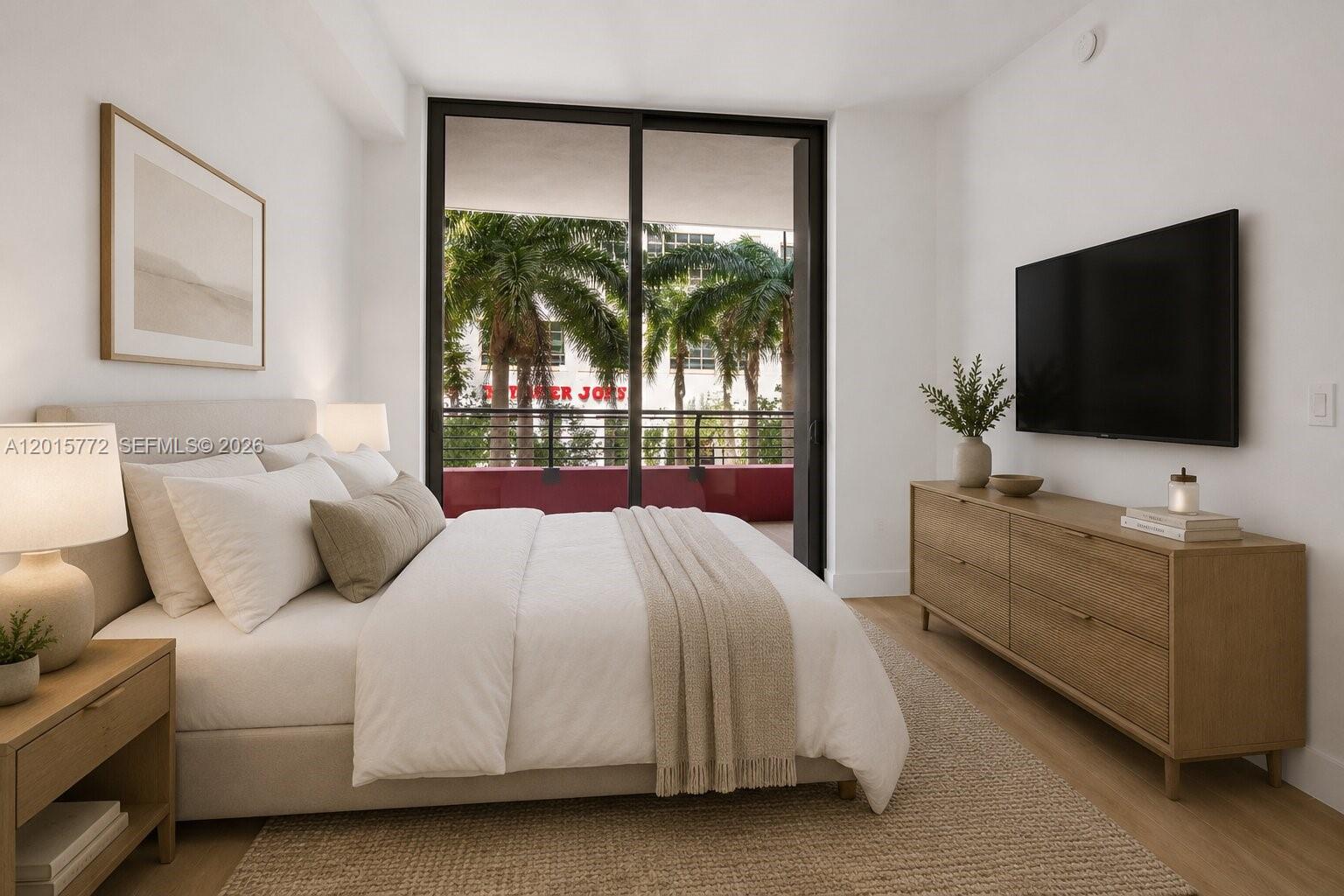 This bedroom features a bed, dresser, wall-mounted television, and a balcony with palm trees — 90 NE 32nd St # 211, Miami FL 33127, MIAMI, FL