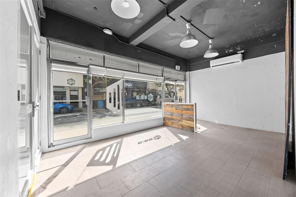 An empty commercial space features tile flooring, a wood-paneled counter, and large storefront windows — 322 MENDEZ VIGO, DORADO, PR