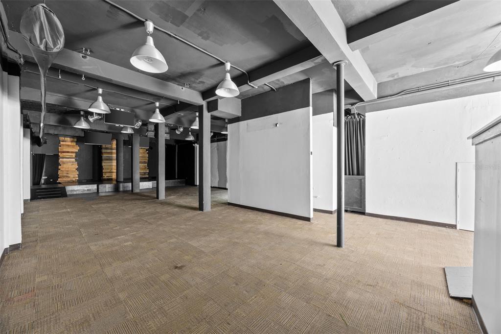 An open commercial space features a dark ceiling, pendant lighting, and carpeted flooring — 322 MENDEZ VIGO, DORADO, PR