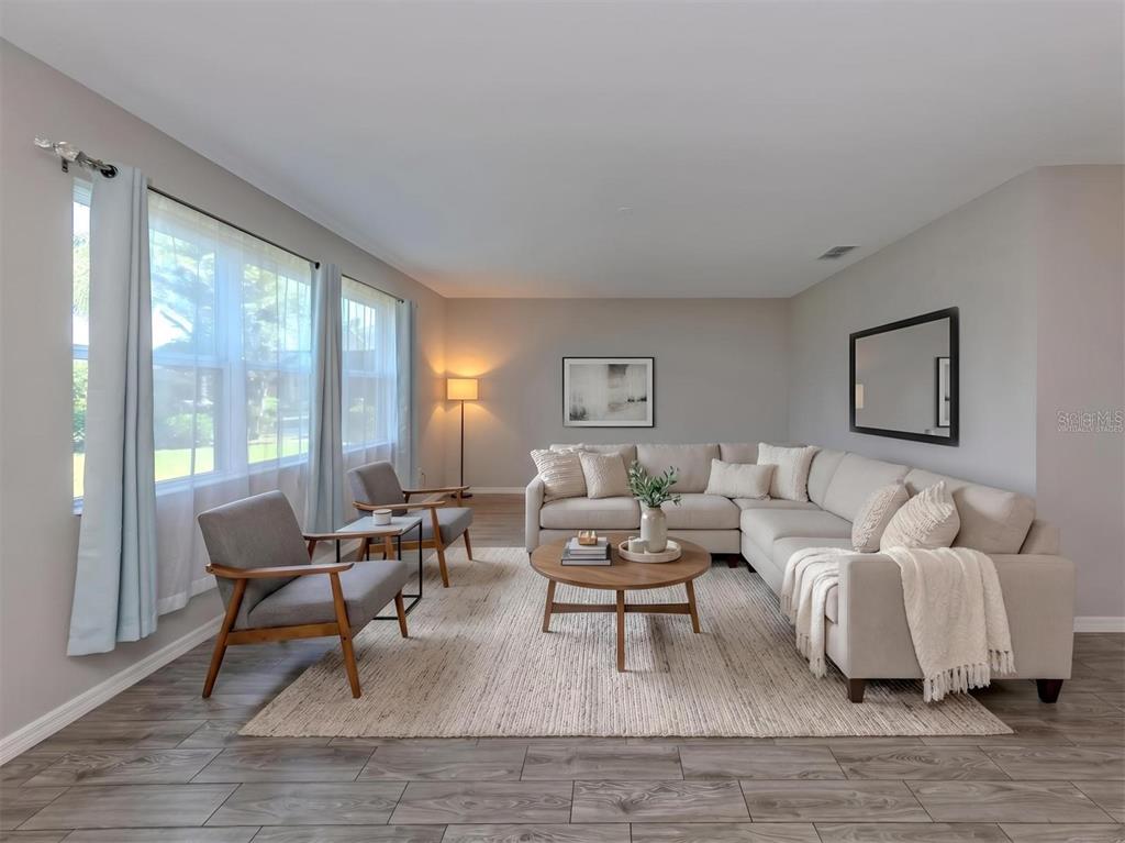 A living room features a sectional sofa, two armchairs, a coffee table, and wood-look flooring — 2160 WEAVER BIRD LANE, VENICE, FL
