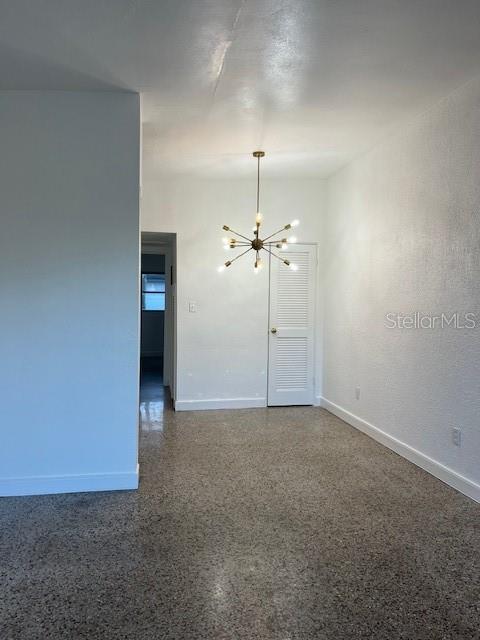 A dining area features a modern sputnik chandelier, white walls, and speckled terrazzo flooring — 1434 MINNESOTA AVENUE, WINTER PARK, FL
