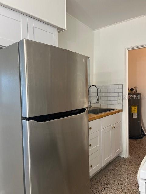 A stainless steel refrigerator stands in a kitchen with white cabinets and subway tile backsplash — 1434 MINNESOTA AVENUE, WINTER PARK, FL