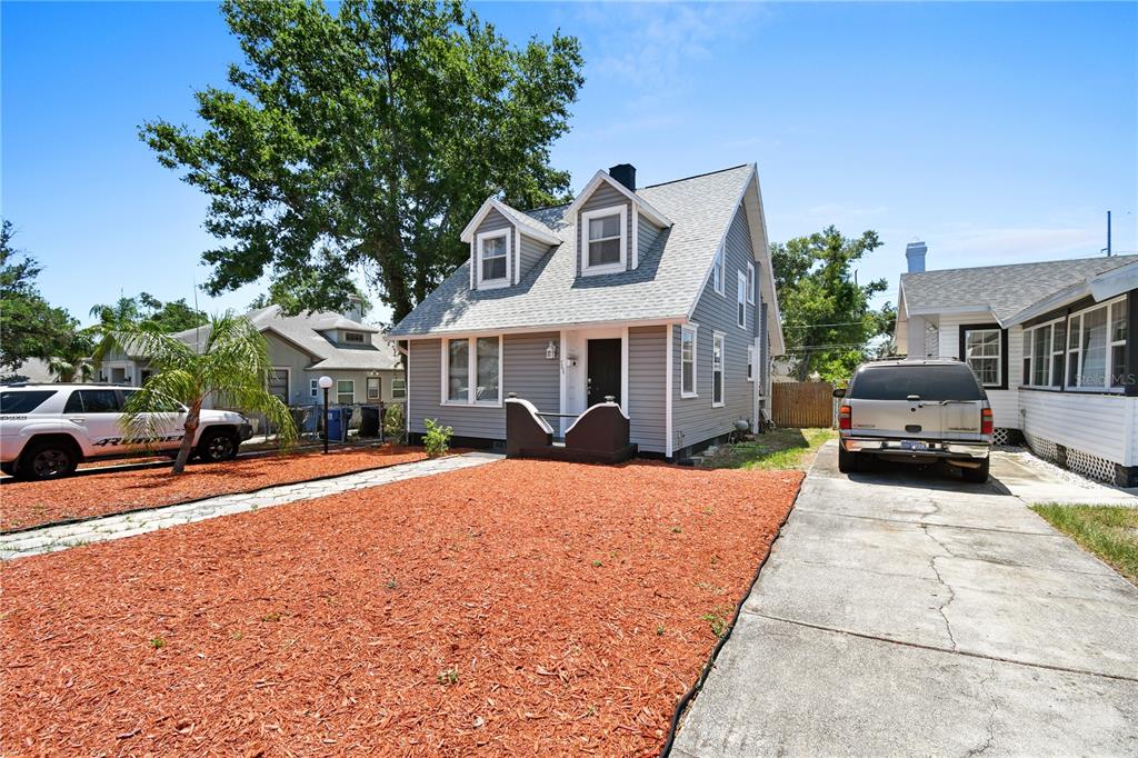 A gray two-story house with a front yard covered in red mulch and a driveway — 766 13TH AVENUE S, ST PETERSBURG, FL