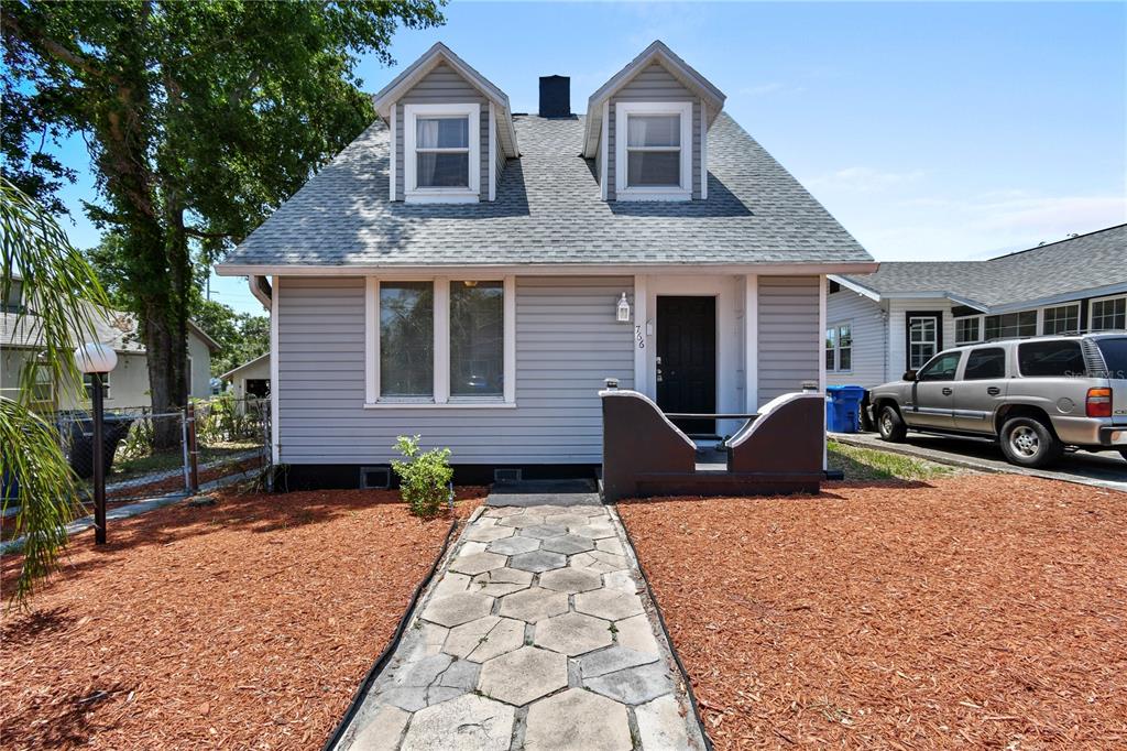 A gray, two-story house with a stone walkway and a small front porch — 766 13TH AVENUE S, ST PETERSBURG, FL