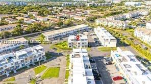 An aerial view shows a multi-story residential complex with parking areas and surrounding green spaces — HOMESTEAD, FL