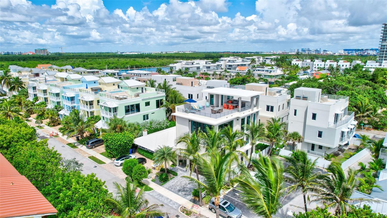 An aerial view shows modern multi-story residential buildings with rooftop terraces and surrounding tropical landscaping — 305 Oak St, Hollywood FL 33019, HOLLYWOOD, FL