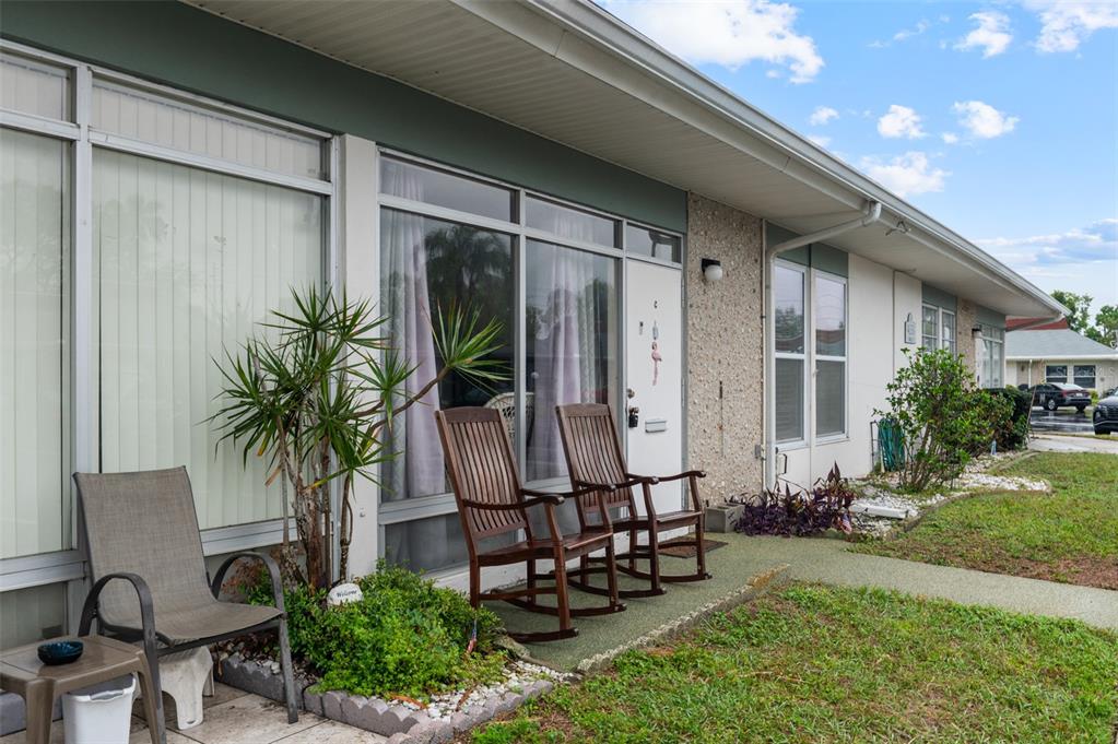 A single-story building exterior features a patio with three chairs and a small table — 4351 TAHITIAN GARDENS CIRCLE UNIT C, HOLIDAY, FL