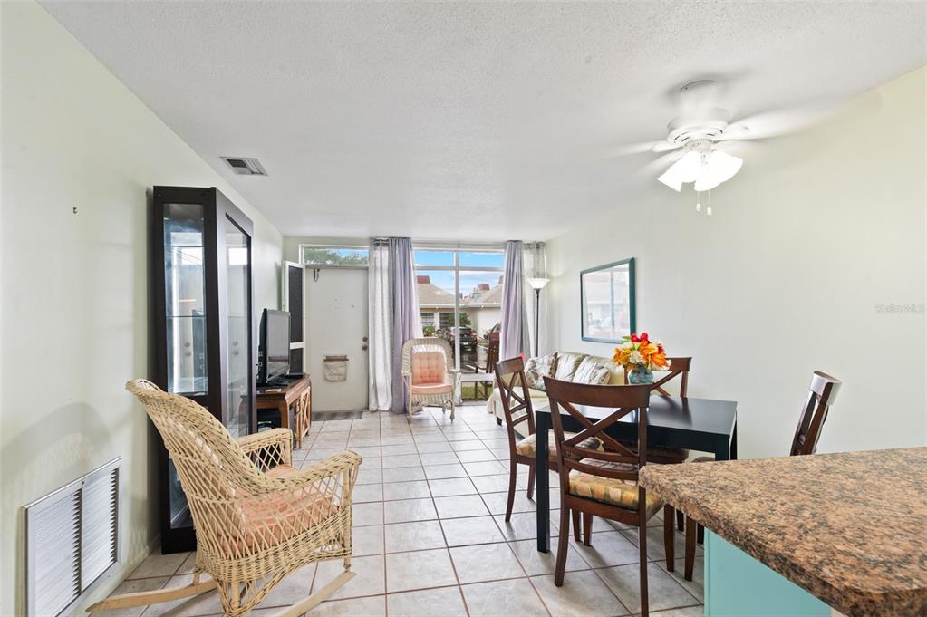 A living and dining area features tile flooring, a ceiling fan, and a glass door — 4351 TAHITIAN GARDENS CIRCLE UNIT C, HOLIDAY, FL