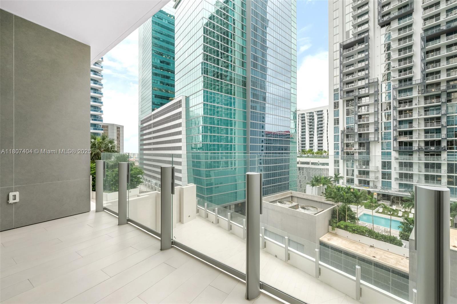 A modern balcony with glass railings overlooks a city skyline with tall glass skyscrapers — 300 Biscayne Blvd Way # 3509, Miami FL 33131, MIAMI, FL