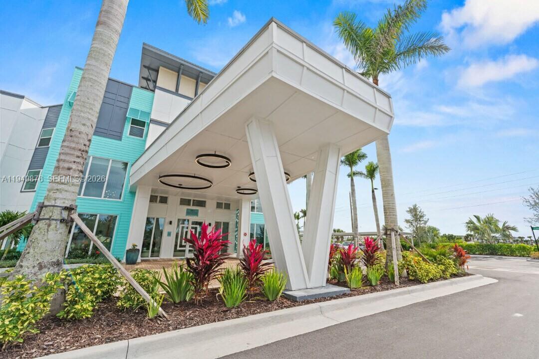 A modern building entrance features a large white V-shaped support column and turquoise siding — 3901 Coast View Pointe # B2, Vero Beach FL 32960, VERO BEACH, FL