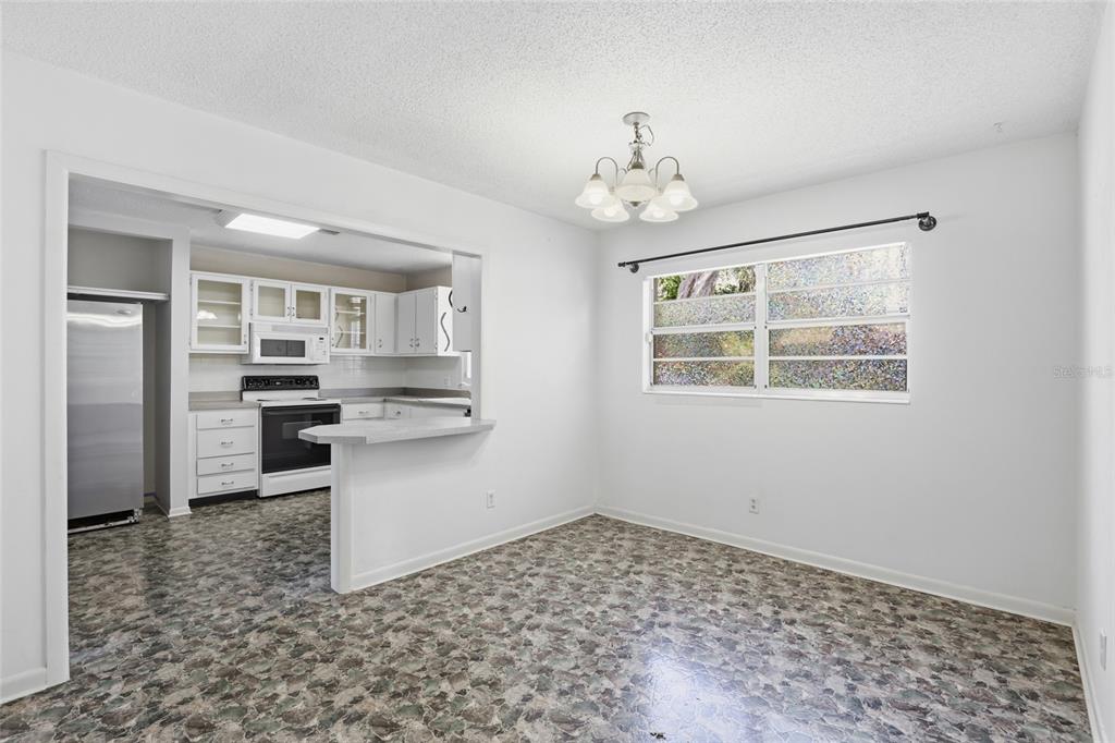 A screened-in patio features a kidney-shaped swimming pool with a built-in step area — 4006 NW 36TH TERRACE, GAINESVILLE, FL