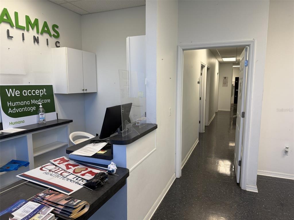 This medical office reception area features a front desk, a computer, and a hallway entrance — 7756 PALM RIVER ROAD, TAMPA, FL