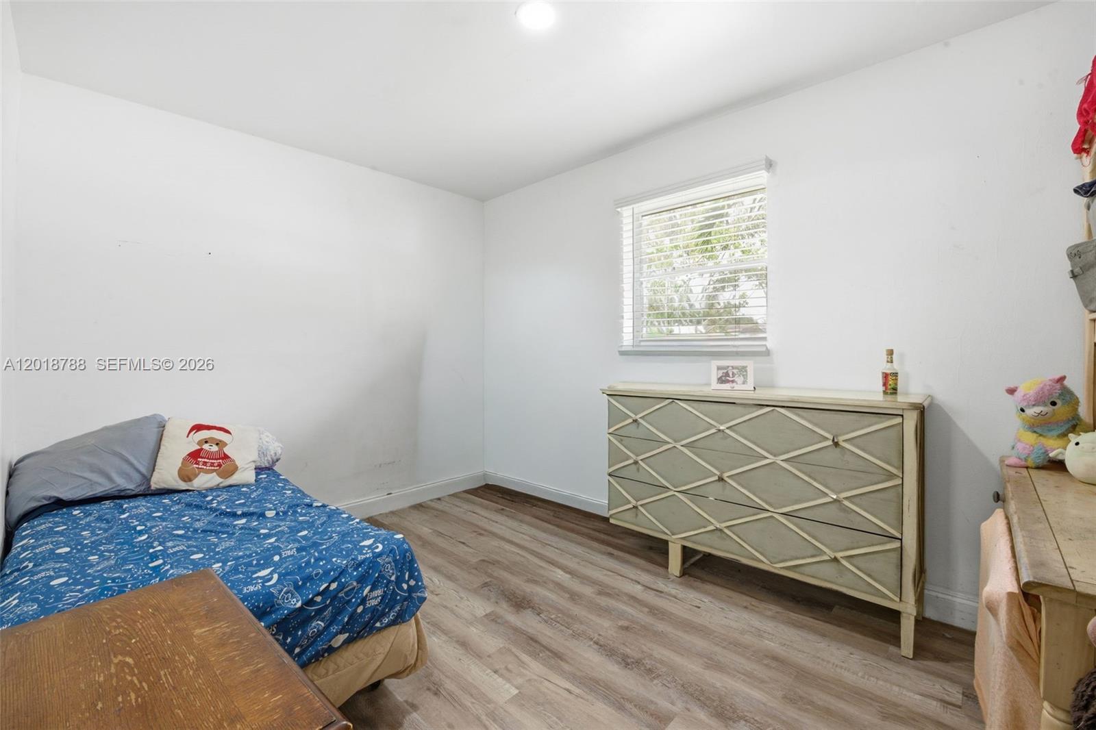A bedroom with white walls, wood-look flooring, a bed, and a decorative dresser — 4621 SW 31st Dr, West Park FL 33023, WEST PARK, FL