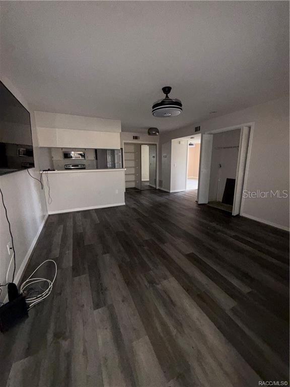 A living room with wood-look flooring, a ceiling fan, and an open kitchen area — 805 SE MAYO DRIVE UNIT 805, CRYSTAL RIVER, FL