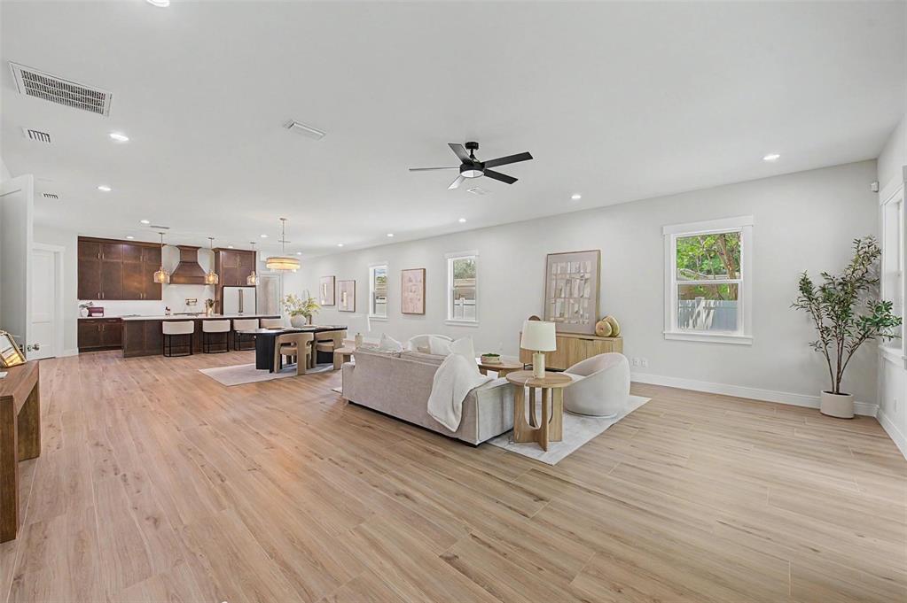 An open-concept living and dining area features light wood flooring, a kitchen, and neutral decor — 110 S ARRAWANA AVENUE UNIT 1, TAMPA, FL