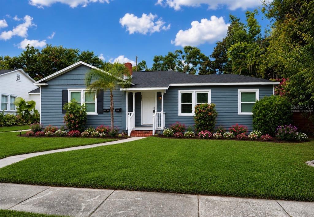 A blue, single-story house with a white front door, dark roof, and landscaped front yard — 3601 6TH AVENUE N, ST PETERSBURG, FL