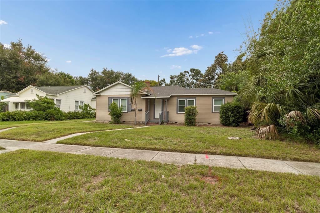 A single-story house with beige siding and a front walkway sits on a grassy lot — 3601 6TH AVENUE N, ST PETERSBURG, FL
