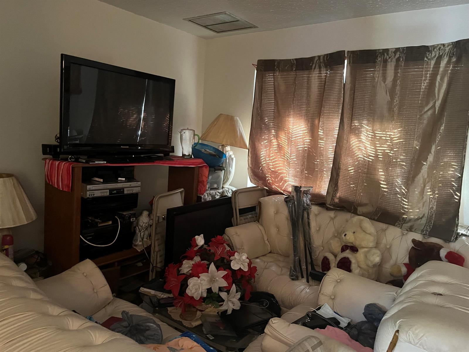 A living room features white tufted sofas, a television on a stand, and brown curtains — 530 S C Street W, FL 33460, FL