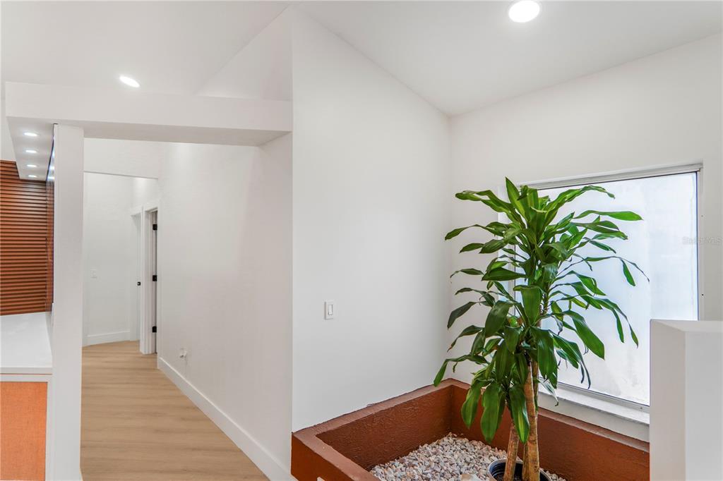A bright interior space features a large potted plant in a stone-filled planter near a window — 2286 LAKE FRANCIS DRIVE, APOPKA, FL