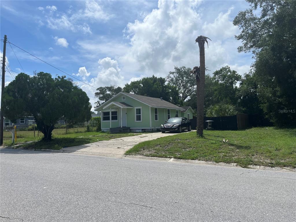 A light green single-story house with a concrete driveway and a palm tree in front — 1161 KINGSLEY STREET, CLEARWATER, FL