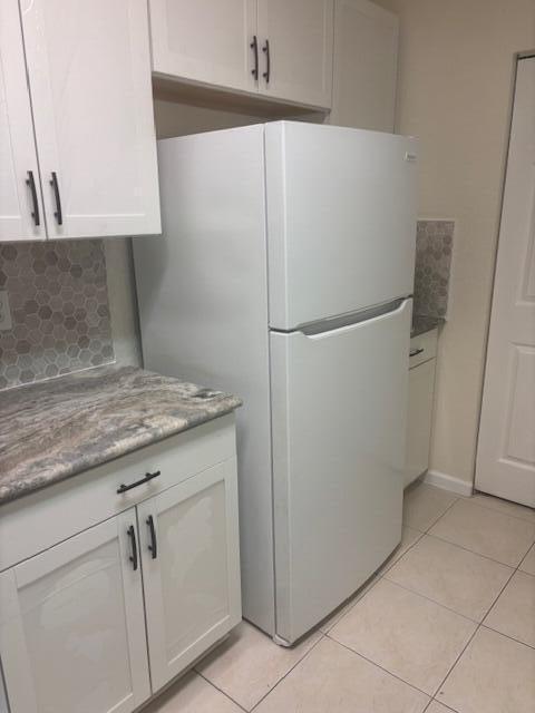 A white refrigerator stands in a kitchen with white cabinets and granite countertops — 3557 Forest Hill Boulevard # 49, Palm Springs FL 33406, PALM SPRINGS, FL