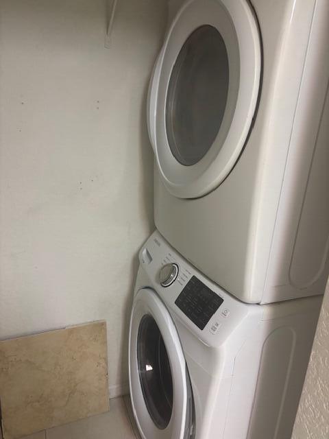 A white stacked washer and dryer unit sits in a small laundry closet — 3557 Forest Hill Boulevard # 49, Palm Springs FL 33406, PALM SPRINGS, FL