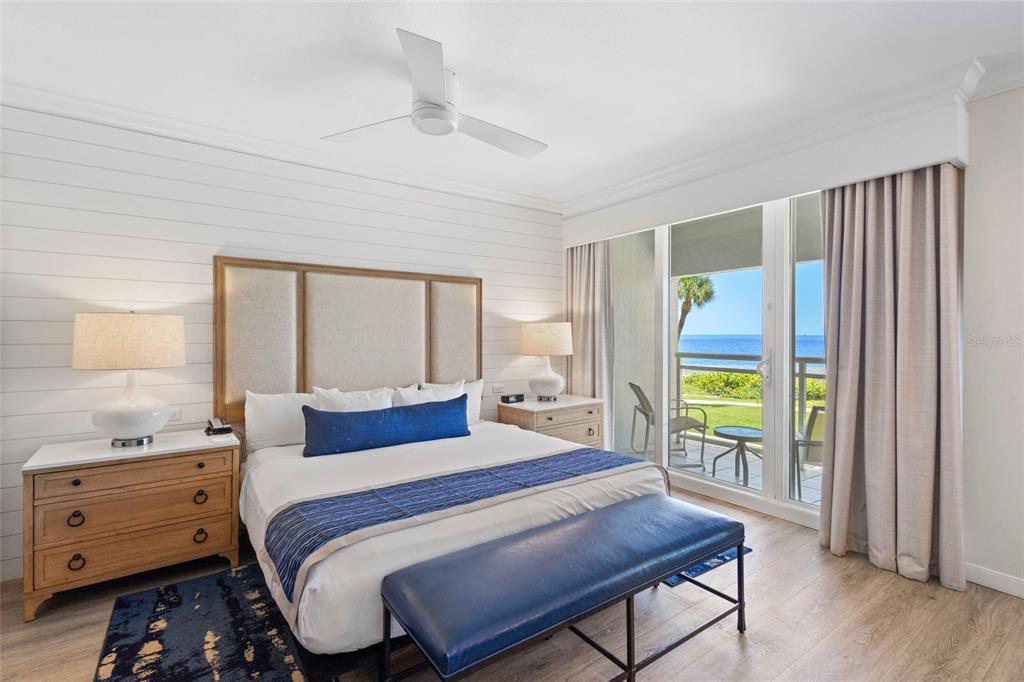 A bedroom features a king bed, shiplap walls, and a sliding door overlooking the ocean — 240 SANDS POINT ROAD UNIT 4104, LONGBOAT KEY, FL