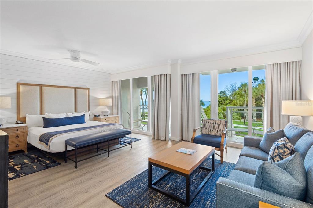 A bedroom with a king bed, sitting area, and sliding glass doors overlooking the ocean — 240 SANDS POINT ROAD UNIT 4104, LONGBOAT KEY, FL