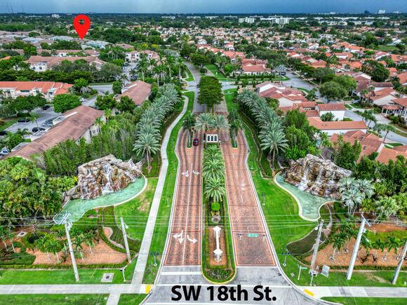 An aerial view shows a gated community entrance with brick roads, waterfalls, and palm trees — 23008 Clear Echo Drive # 11, Boca Raton FL 33433, BOCA RATON, FL
