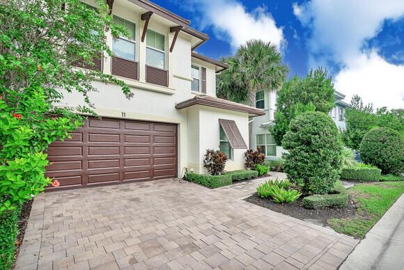 A two-story house with a brown garage door and a paved driveway under a blue sky — 23008 Clear Echo Drive # 11, Boca Raton FL 33433, BOCA RATON, FL