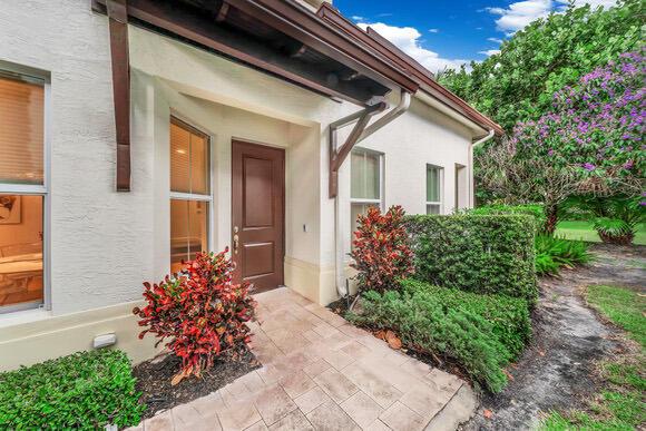 A paved walkway leads to a brown front door beside a landscaped garden and house — 23008 Clear Echo Drive # 11, Boca Raton FL 33433, BOCA RATON, FL