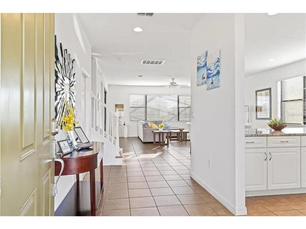A view from an entryway looking into a living room with tile floors and stairs — 2654 ROSEMONT CIRCLE, DAVENPORT, FL