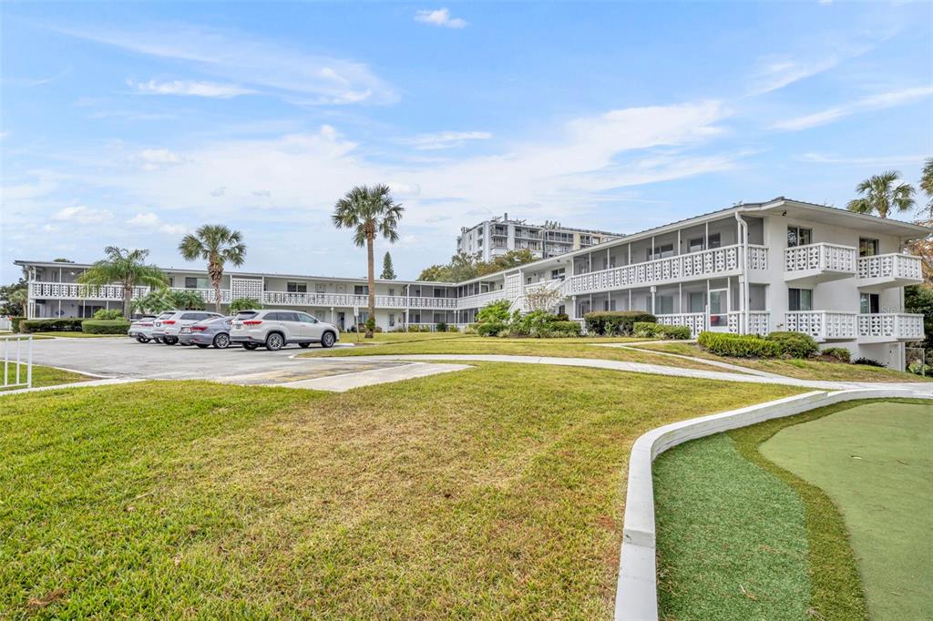Exterior view of a multi-story apartment complex with a parking lot and grassy lawn — 1140 S ORLANDO AVENUE UNIT K15, MAITLAND, FL