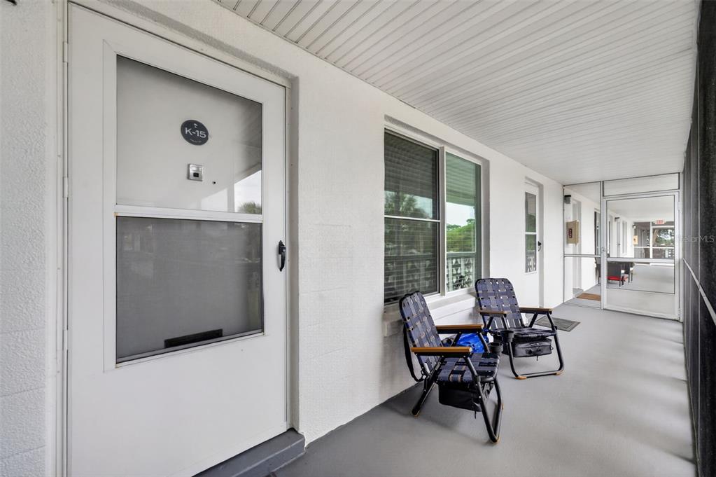 A white door labeled K-15 opens onto a screened-in porch with two folding chairs — 1140 S ORLANDO AVENUE UNIT K15, MAITLAND, FL