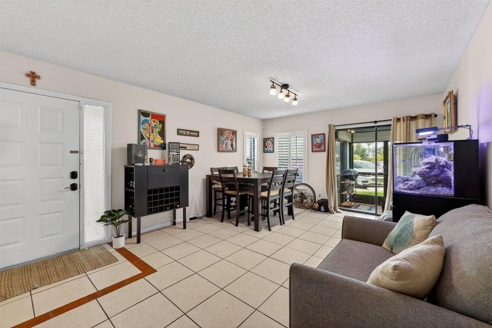 A living and dining area with tile flooring, a dining table, a sofa, and an aquarium — 950 S Kanner Highway # 603, Stuart FL 34994, STUART, FL