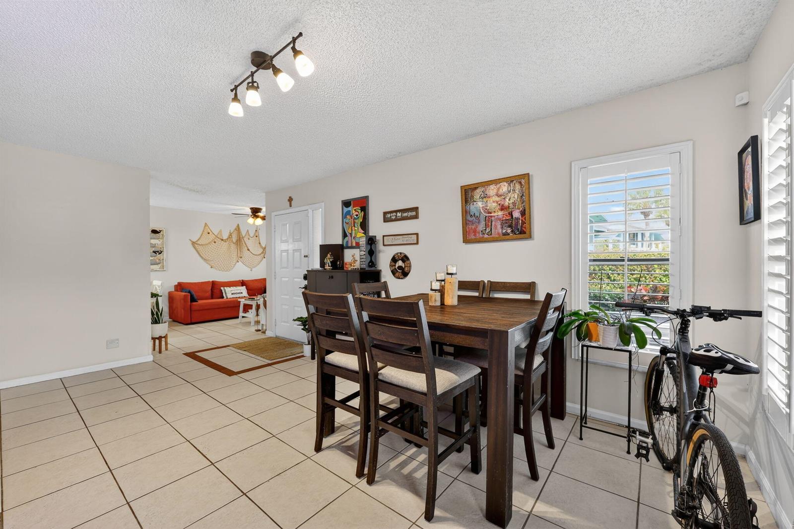 A dining area with a wooden table and chairs sits adjacent to a living room — 950 S Kanner Highway # 603, Stuart FL 34994, STUART, FL