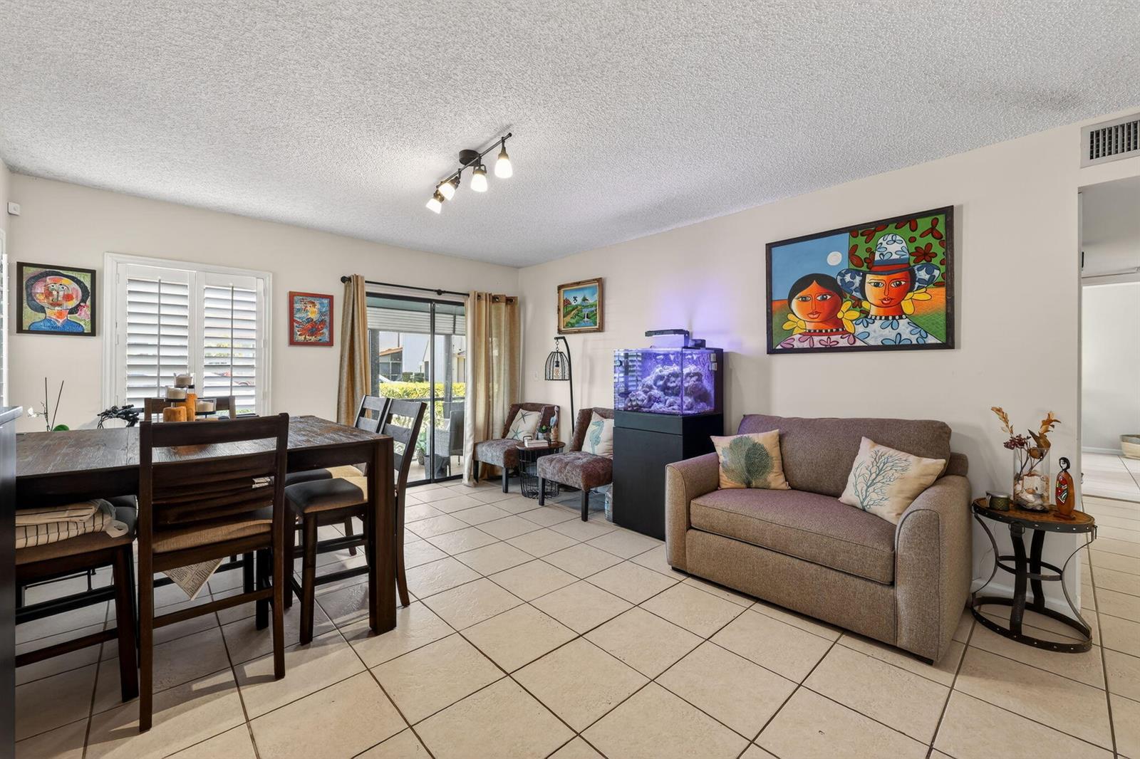 A dining and living area features tile floors, a dark wood table, and a fish tank — 950 S Kanner Highway # 603, Stuart FL 34994, STUART, FL